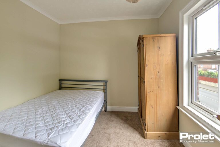 Double bedroom with bed, drawers and wardrobe.