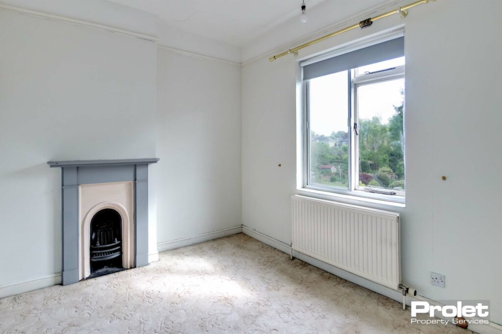 Cream carpet with white walls. Feature fireplace with grey surround