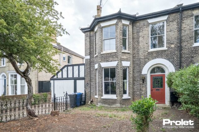 Front external property with red door, garage, rear garden access door and driveway