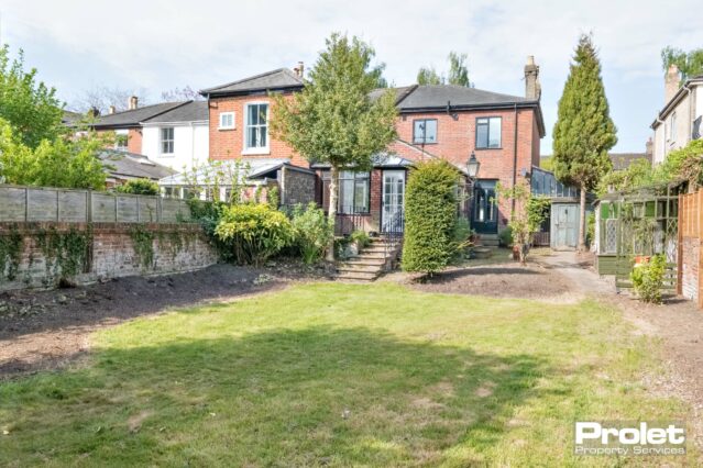 Steps into garden with lawn arear and brick walls