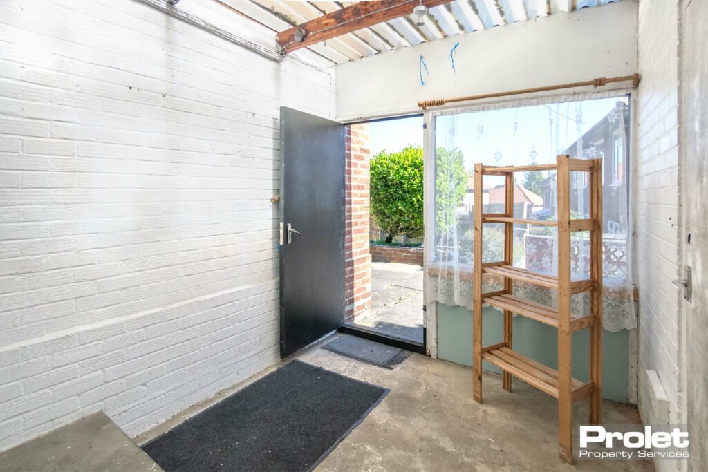 Concrete floor with white walls and external door