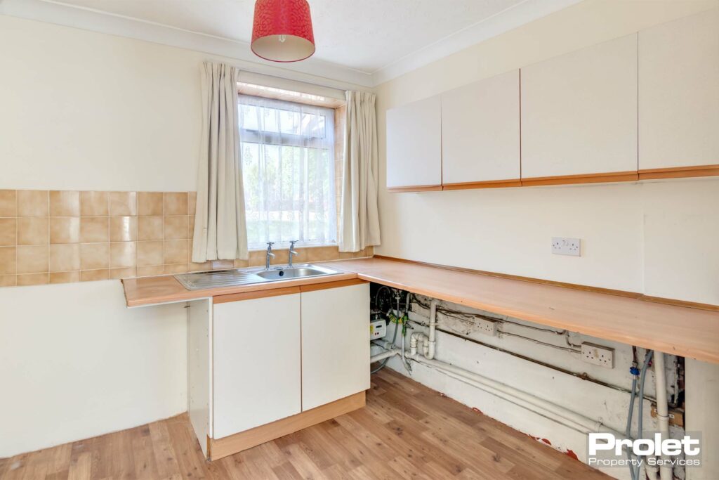 Laminate flooring with white units and beech effect worktops
