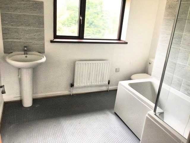 Bathroom with shower over bath and sink