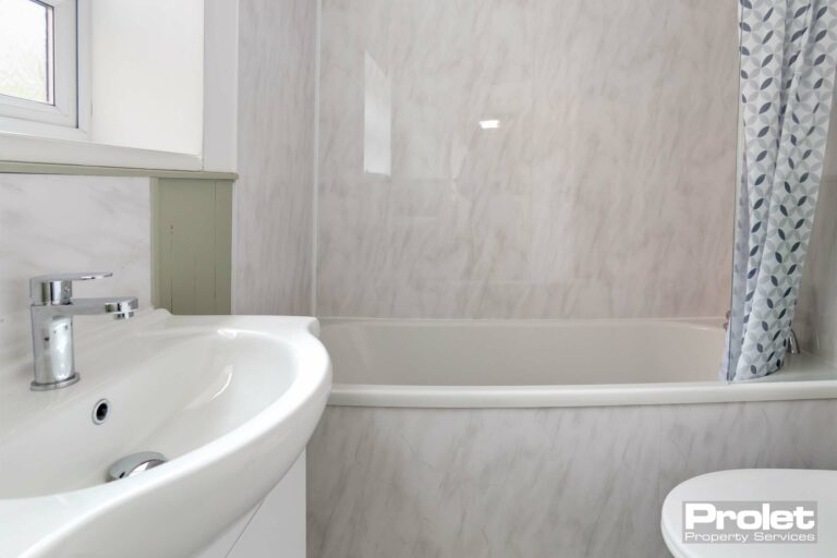 Bathroom with shower over bath, toilet, and sink