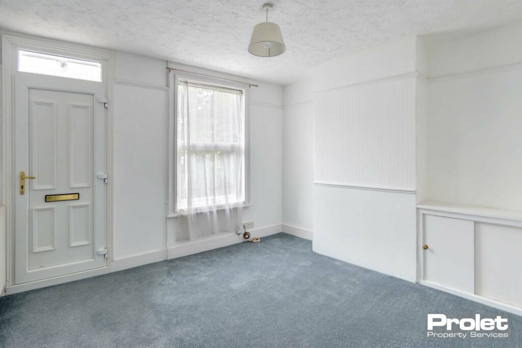 Living room, with grey carpet and white walls
