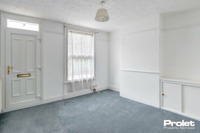 Living room, with grey carpet and white walls