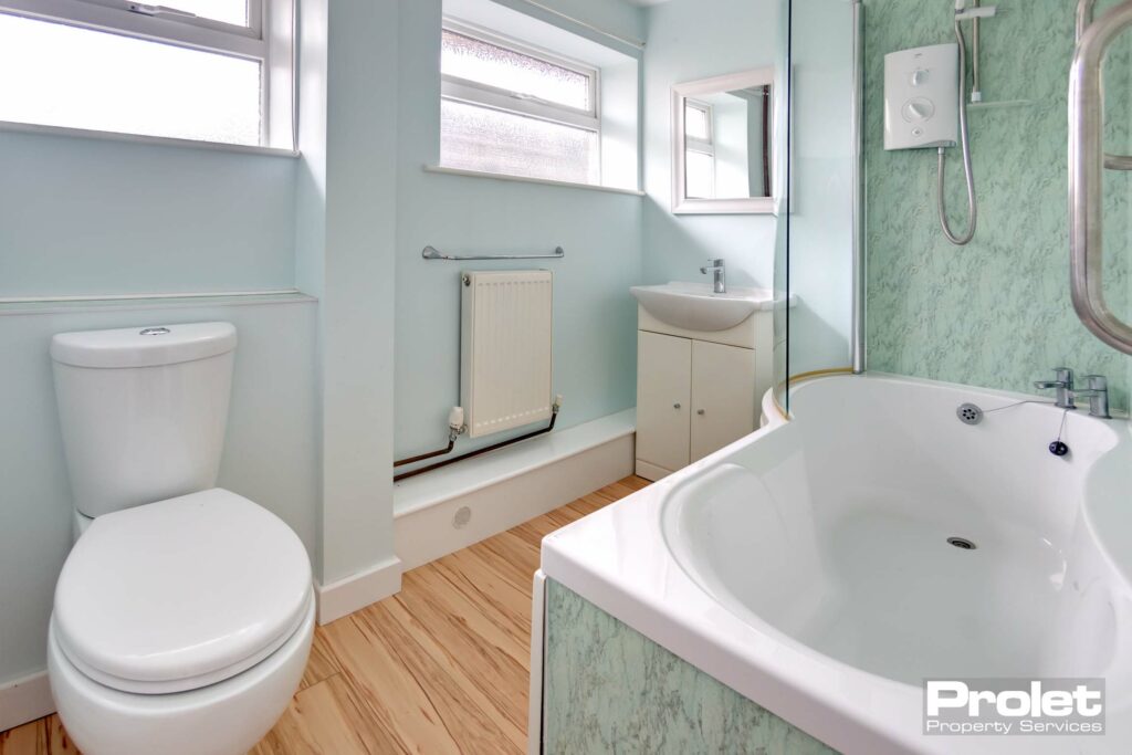 Bathroom with shower over bath, toilet, and sink