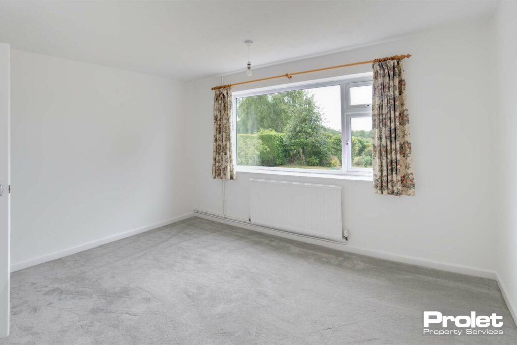 Bedroom with white walls and grey carpet