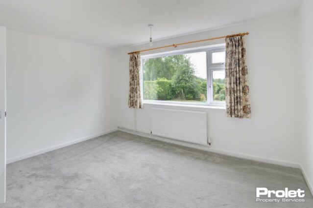 Bedroom with white walls and grey carpet