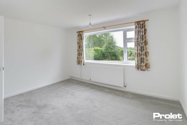 Bedroom with white walls and grey carpet
