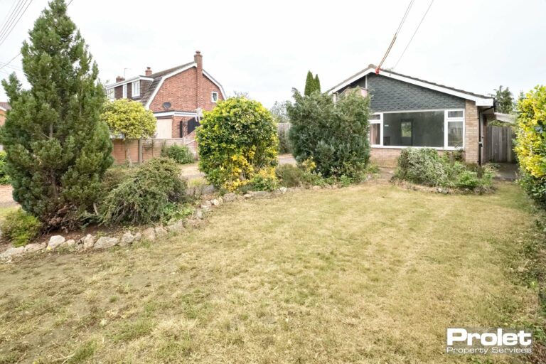 View of property, lawn and shrubs