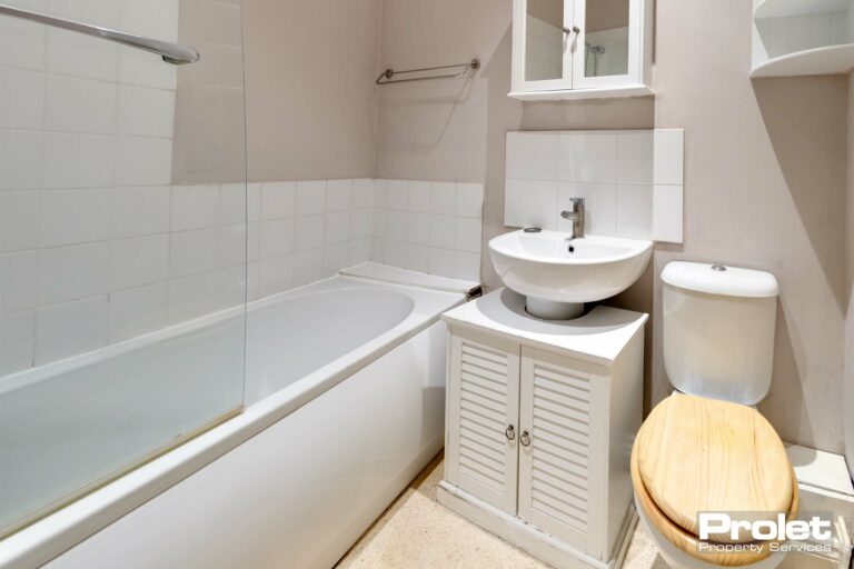 Bathroom with shower over bath, sink, and toilet