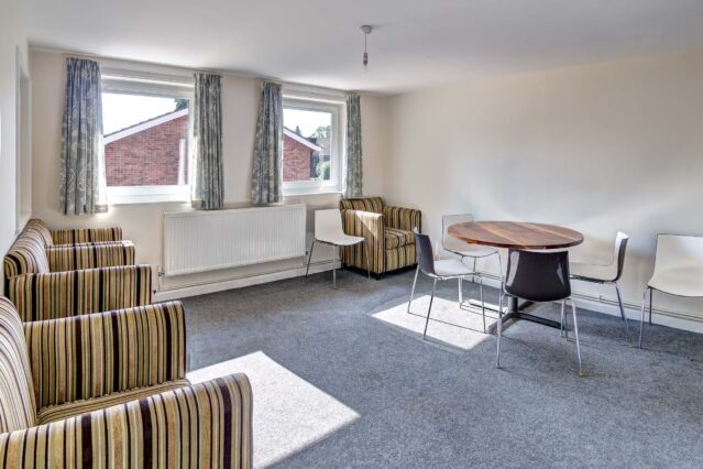 Grey carpet with off white walls, striped sofas and dining set