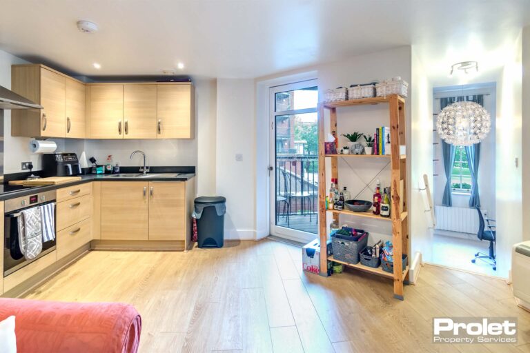 Laminate flooring and white walls with access to balcony.