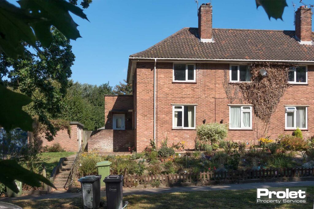Red brick building with driveway parking