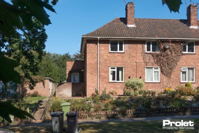 Red brick building with driveway parking
