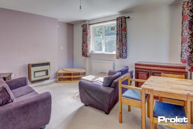 Lounge with beige flooring, two sofas, dining set, TV unit, sideboard and coffee table