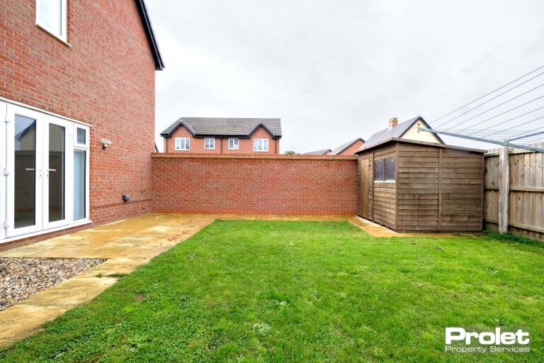 Rear garden with brick wall, patio area and grass