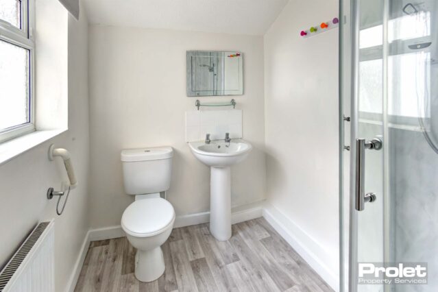 Bathroom with shower cubicle, sink, and toilet.