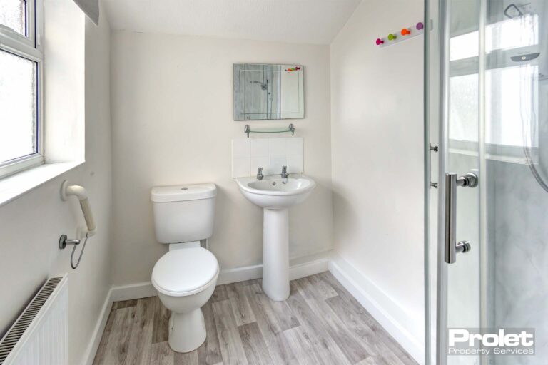 Bathroom with shower cubicle, sink, and toilet.