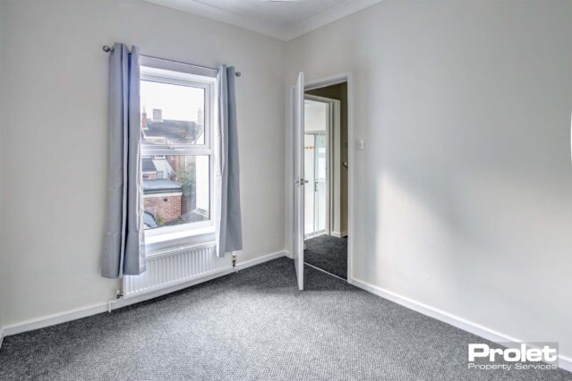 Bedroom with white walls and grey carpet
