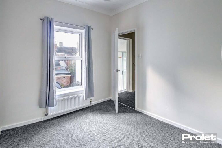 Bedroom with white walls and grey carpet