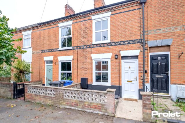 Terraced house with white door and low wall at front