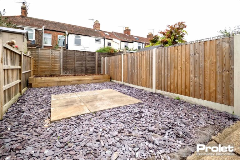 Rear garden with patio area, slate gravel, and a raised bed