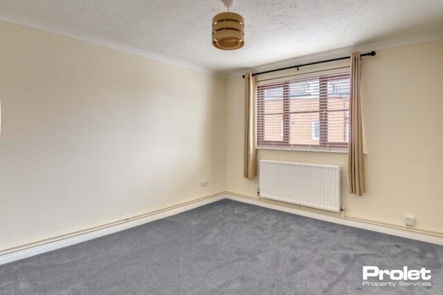 Grey carpets, magnolia walls and gas central heating with radiator under window