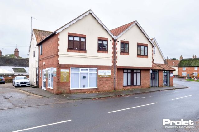 Brick building with cream render. First floor flat over garage