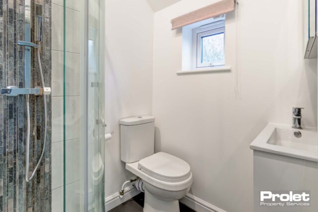 Shower room with walls painted white and white suite