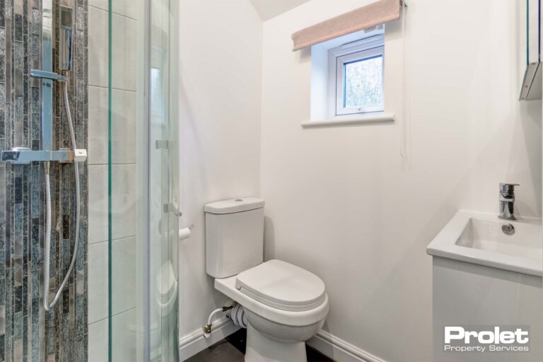 Shower room with walls painted white and white suite