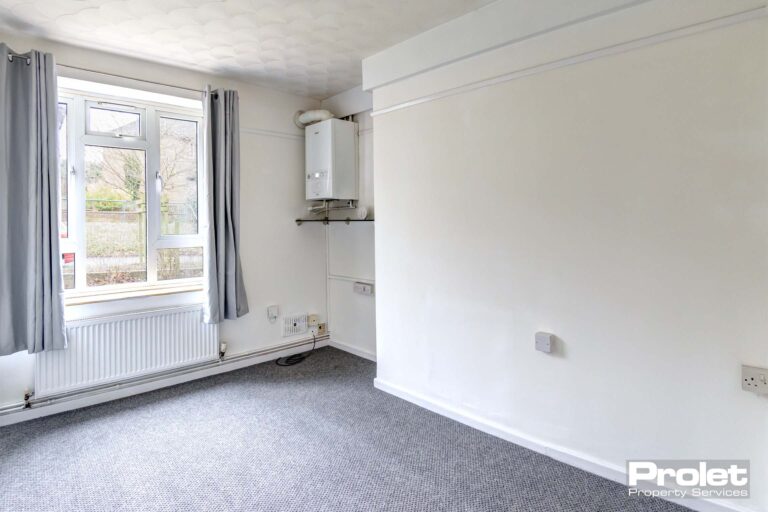 Study room with grey carpets, white walls and large window