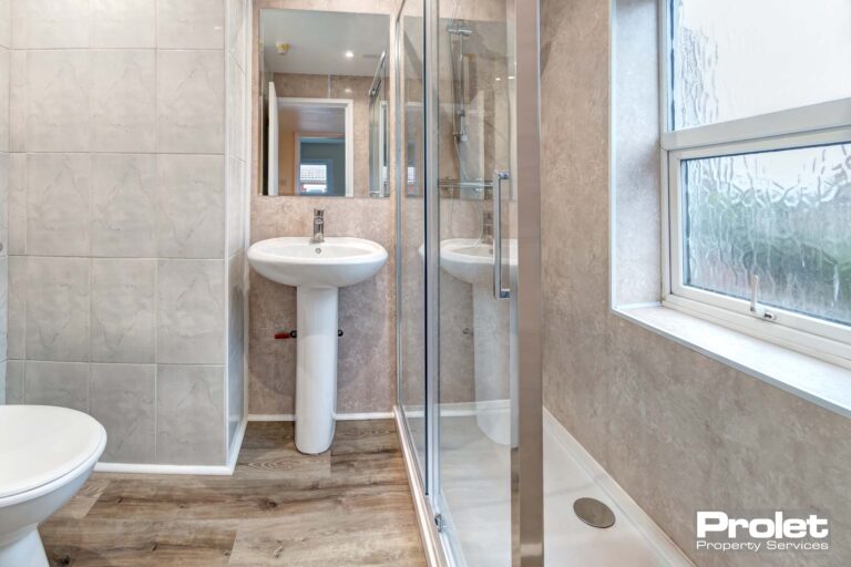 laminate flooring with white suite and glass showerscreen