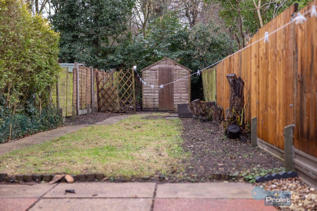 Rear garden with patio, lawn, and shed.