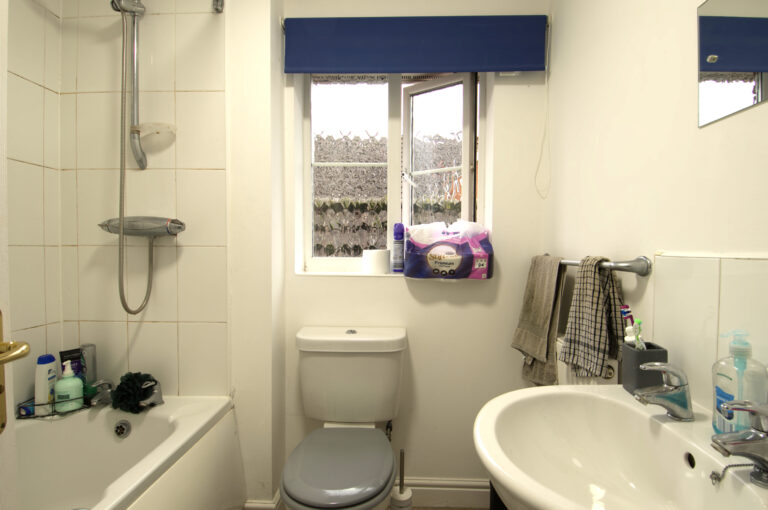 Family bathroom, with shower over bath, toilet, and sink