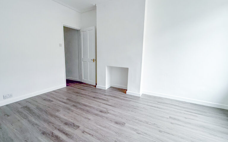 Living room with laminate wood effect flooring and white walls
