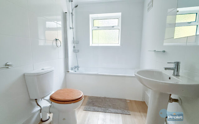 Bathroom with shower over bath, toilet, and sink