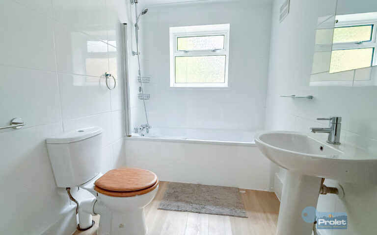 Bathroom with shower over bath, toilet, and sink