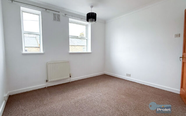 Bedroom with white walls and brown carpet