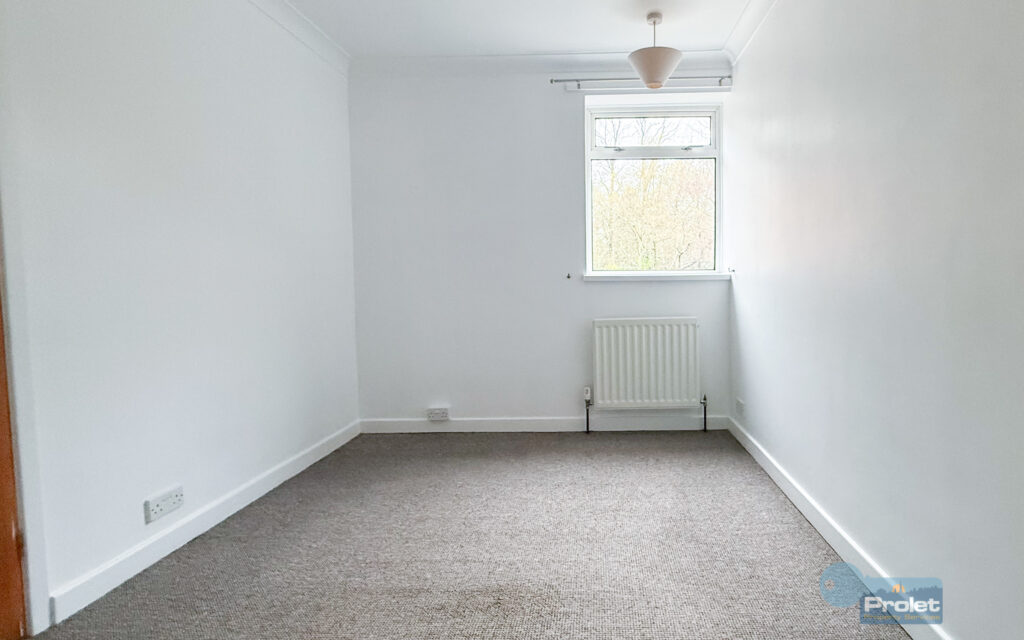 Bedroom with white walls and brown carpet