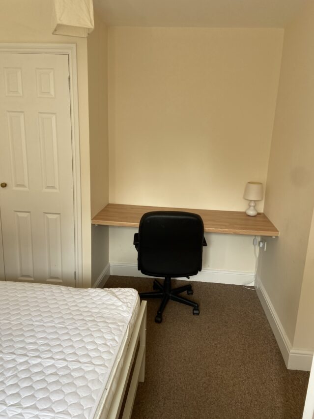 Bedroom with double bed, desk, and desk chair