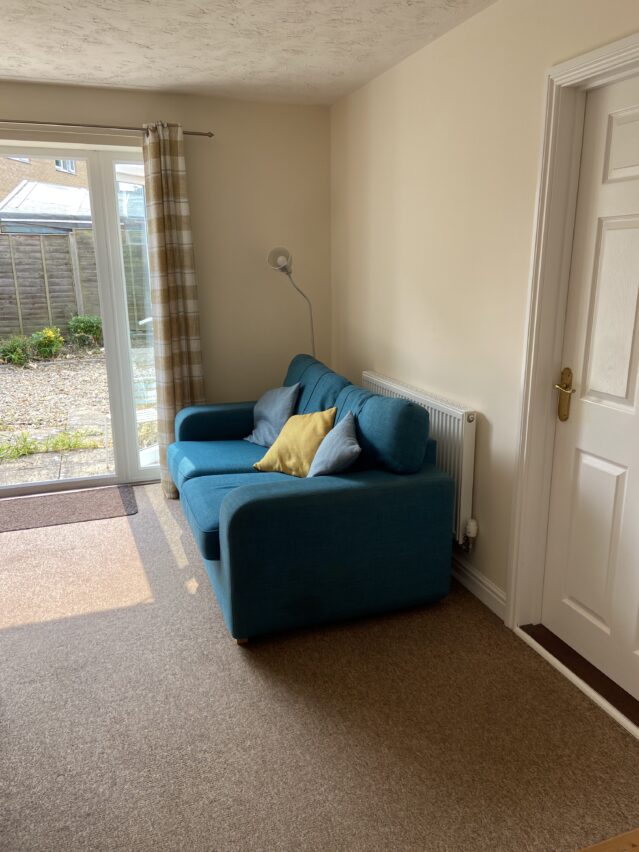Lounge with glass door to garden and blue sofa
