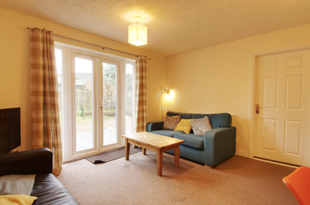 Living room with patio doors to garden, furnished with sofas